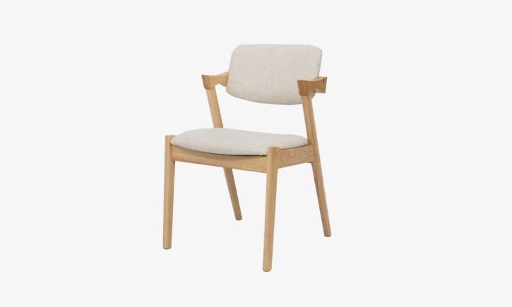 Angled view of Atlas Dining Chair made of rubber wood upholstered with cream fabric