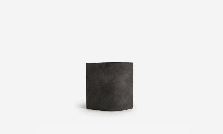 Minimalist rectangular vase with a textured surface and curved body.