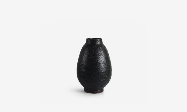 Tall, black ceramic vase with a textured surface.