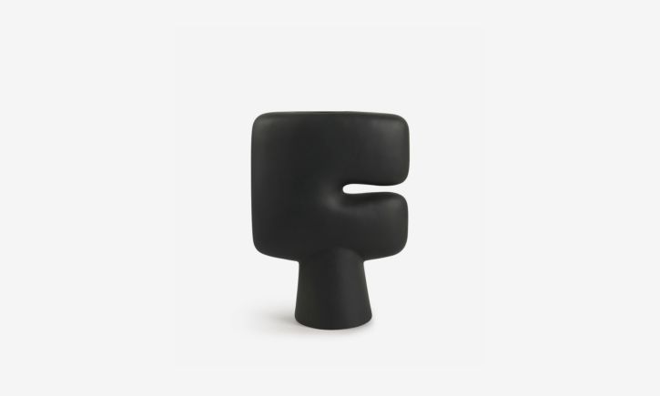 Textured black ceramic vase with an abstract, sculptural form.