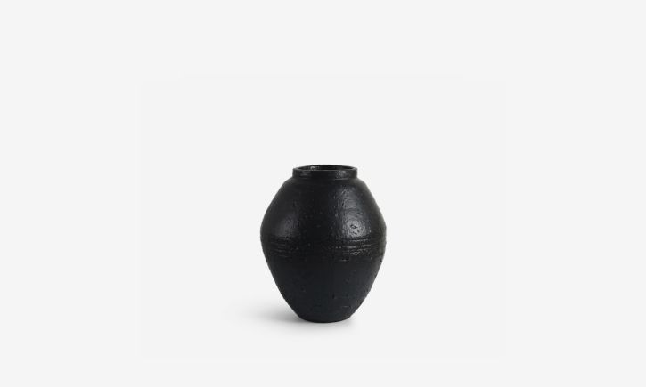 Black ceramic vase with a textured surface.