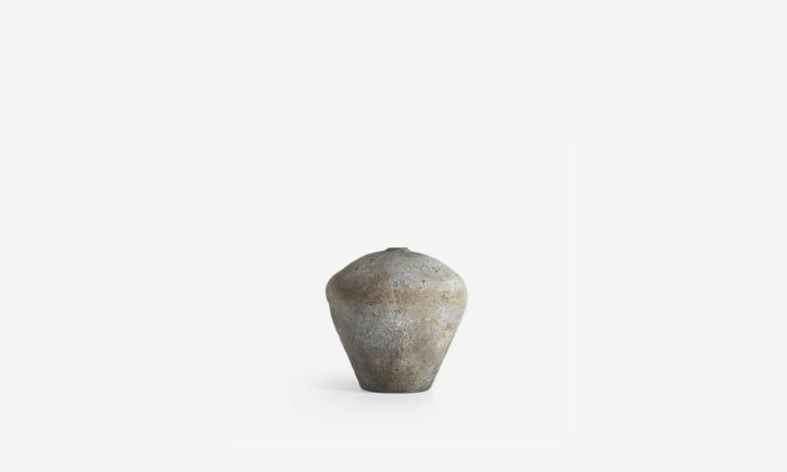 A wide, rustic vase with a narrow top features a charming, weathered design that gives it a timeless, vintage appeal.